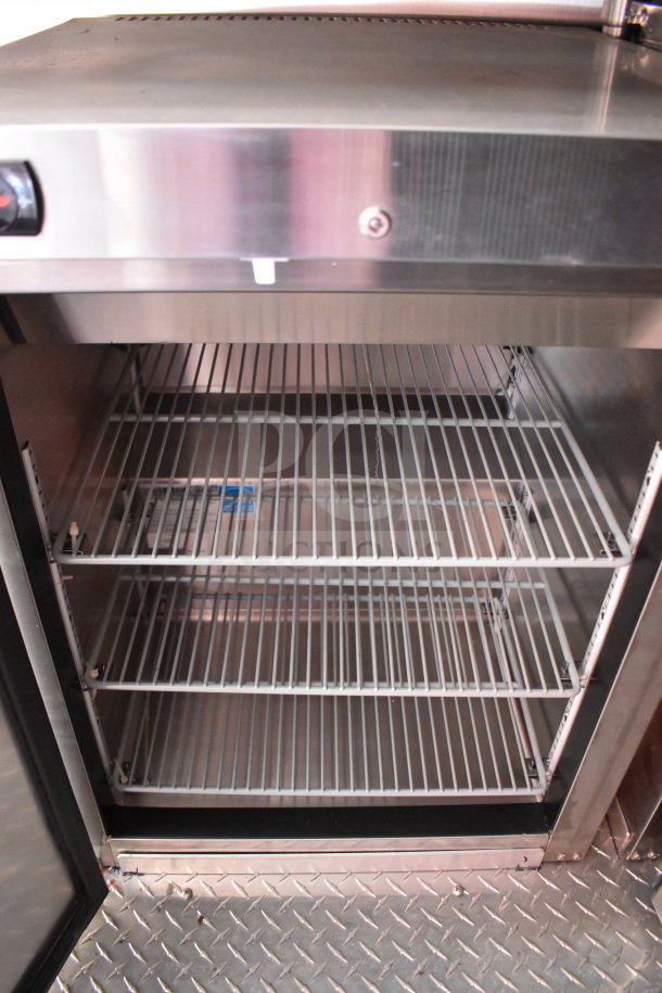 Stainless steel interior of 2022 Rock Solid Cargo food trailer with wire shelving in excellent condition.