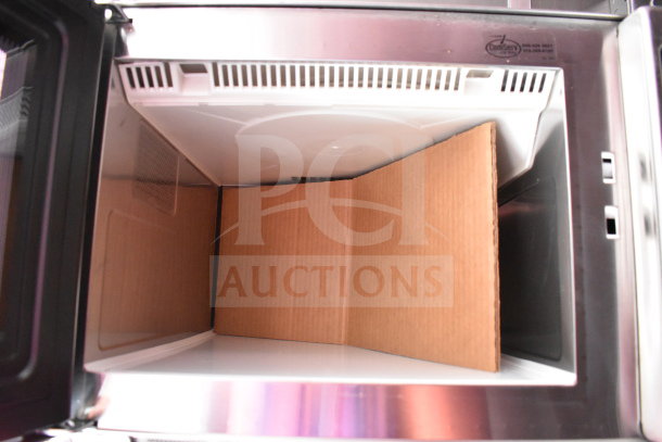 Interior view of a stainless steel appliance in the 2022 Rock Solid Cargo food trailer. Features DeliServe logo inside.
