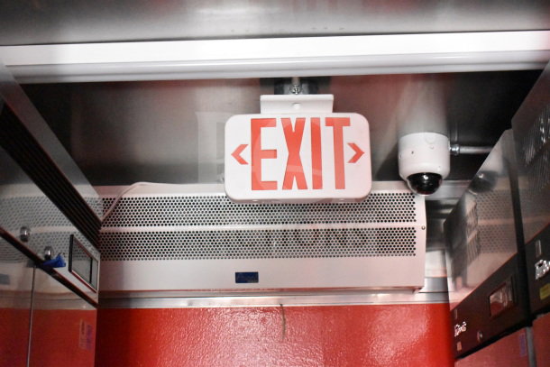 Interior of 2022 Rock Solid Cargo food trailer with CaptiveAire hood, visible exit sign, camera, and air vent.