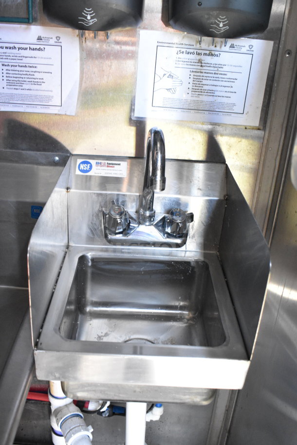 Stainless steel sink in Titanium Cargo Trailer, featuring dual faucet handles and NSF certification visible.