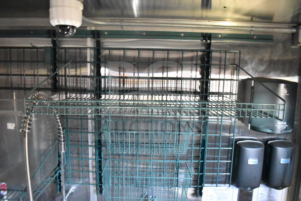 Titanium Cargo Trailers 8.5'x28' interior view with wire shelving, CaptiveAire hood, and dispensers. Ideal for a mobile kitchen.