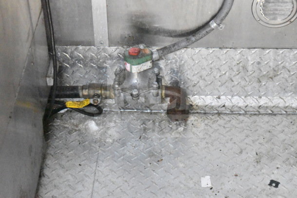 Interior view of Titanium Cargo Trailer, showing a gas valve component installed on a diamond plate floor, part of food trailer setup.