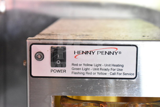 Henny Penny fryer power switch with indicator lights and operating instructions displayed.