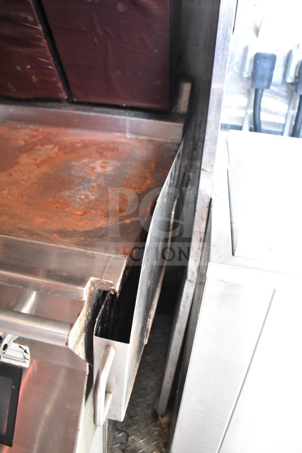 Titanium Cargo 8.5'x28' food trailer; CaptiveAire grease hood, rust and use visible, includes refrigeration suite.
