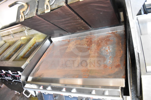 Food trailer interior showing a well-used grill with rust and grease stains, part of a Titanium Cargo 8.5'x28' trailer setup.
