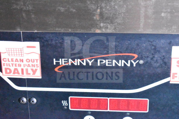 Henny Penny fryer control panel with "Clean Out Filter Pans Daily" sticker visible.
