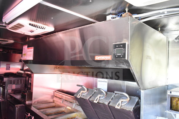 Titanium Cargo Trailers 8.5'x28' food trailer interior with CaptiveAire grease hood, fryers, and refrigeration; visible equipment labels.