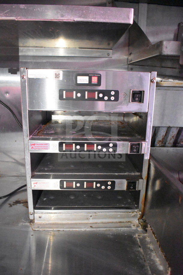 Titanium Cargo Trailer kitchen equipment, featuring stainless steel warming drawer units with control panels and caution labels.