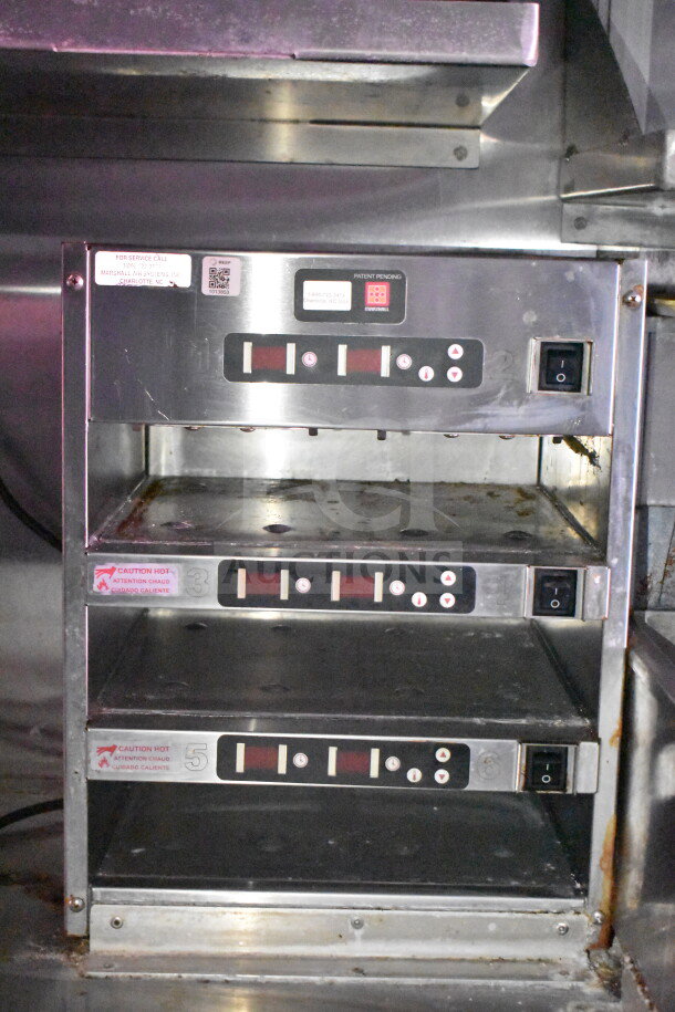 Stainless steel warming drawers inside Wendy's food trailer with digital controls and caution hot labels, part of Titanium Cargo Trailers setup.