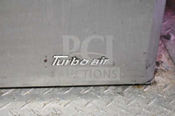 Titanium Cargo Trailer Turbo Air branding on stainless steel surface; close-up view.