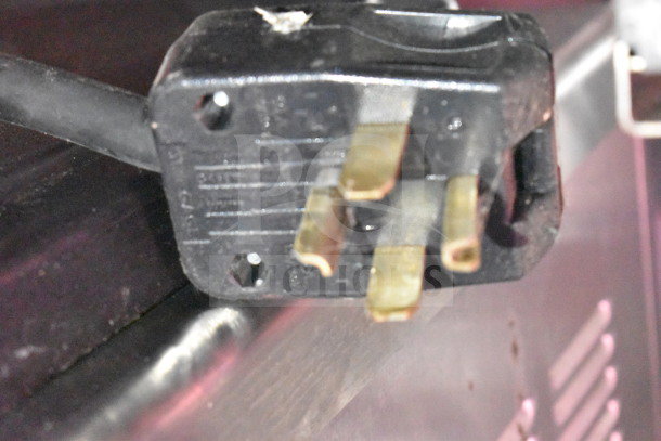 Power plug of Titanium Cargo Trailers 8.5'x28' food trailer, featuring industrial-grade prongs and a black casing.