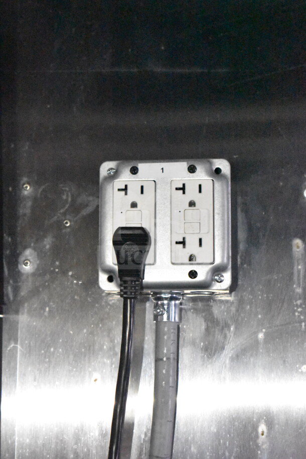 Electrical outlet inside Titanium Cargo Trailer, model 8.5'x28', featuring dual sockets with one plugged in.