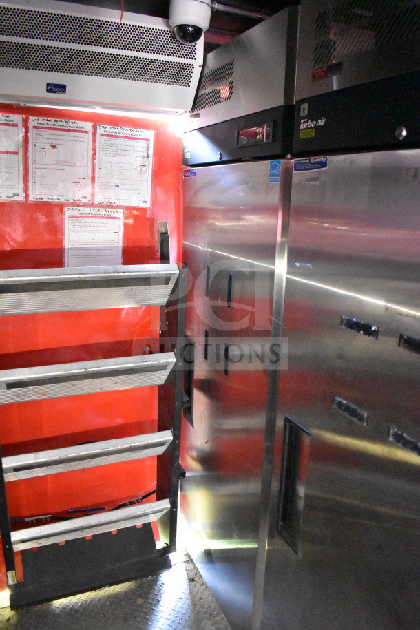 Titanium Cargo Trailers 8.5'x28' food trailer interior with stainless steel refrigeration, shelves, and equipment labels.