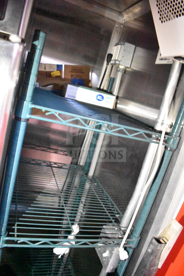 Interior view of Titanium Cargo Trailer, showcasing sturdy metal shelving with electrical wiring alongside.