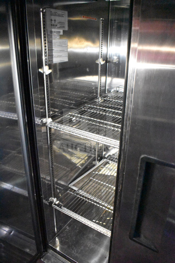 Inside view of a refrigerated section in a Titanium Cargo Trailer. Features wire shelving and visible Turbo Air label.
