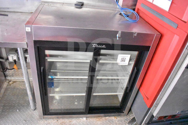True refrigeration unit in Titanium Cargo Trailers 8.5'x28' food trailer. Features glass doors, shelving. Model specifics unavailable.