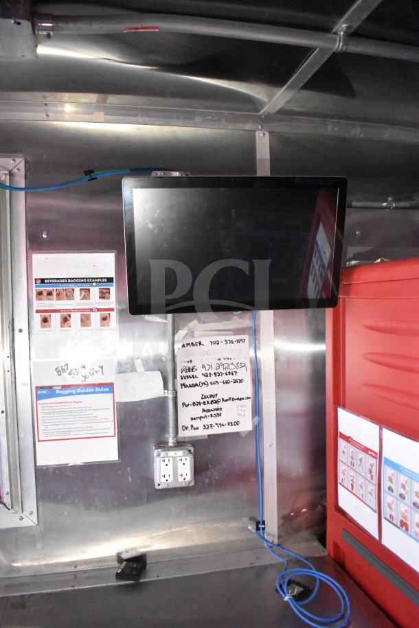 Titanium Cargo Trailers 8.5'x28' Wendy's food trailer interior, featuring a wall-mounted monitor, instructional signage, and an electrical outlet.