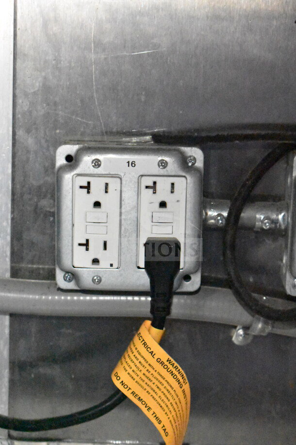 Electrical outlet in Titanium Cargo Trailers food trailer with warning tag attached.