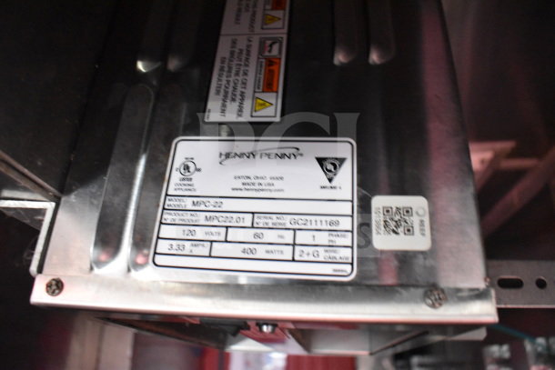 Henny Penny Fryer label with model MPC-22, specs: 120V, 60Hz, 400W, serial GC2111169. Stainless steel surface.