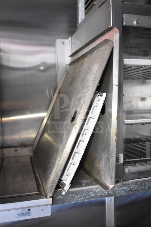 Inside view of 2021 Titanium Cargo Trailers Wendy's Food Trailer, showing metal storage shelves with some signs of wear.