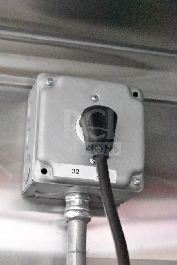 Electrical outlet in 2021 Titanium Cargo Trailers food trailer, attached to metal casing, labeled with the number 32.