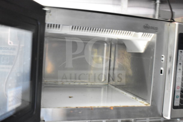 Interior view of a microwave inside the 2021 Titanium Cargo Trailers 8.5'x28' food trailer, showing some visible wear.