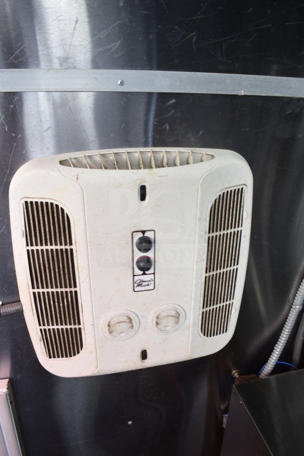 Wall-mounted white ventilation unit with two dials and vents, installed in a 2021 Titanium Cargo Trailers food trailer.