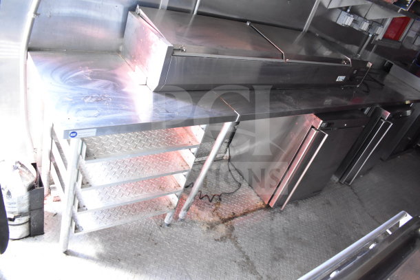 2021 Titanium Cargo Trailers 8.5'x28' Wendy's Food Trailer interior, featuring stainless steel countertops and refrigeration units.