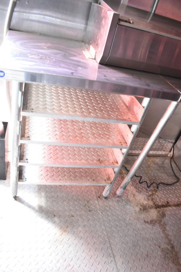 2021 Titanium Cargo Trailers 8.5'x28' Wendy's Food Trailer interior view featuring a stainless steel prep table over diamond-plate flooring.