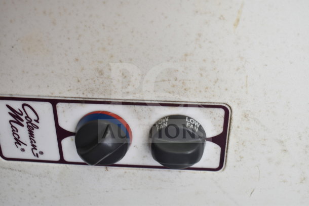 Control knobs of a Coleman Mach device, showing temperature and fan settings, with visible wear and dirt.