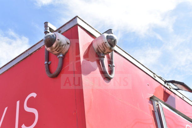 Red 2021 Titanium Cargo Trailer exterior, featuring security cameras and ventilation on the roof corner.