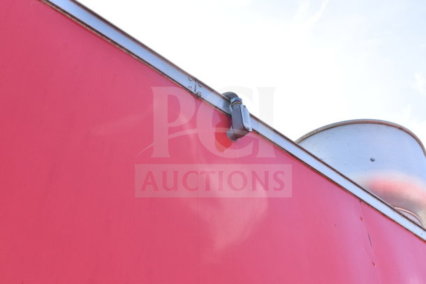 Red exterior of 2021 Titanium Cargo Trailer, ventilation detail visible on edge.