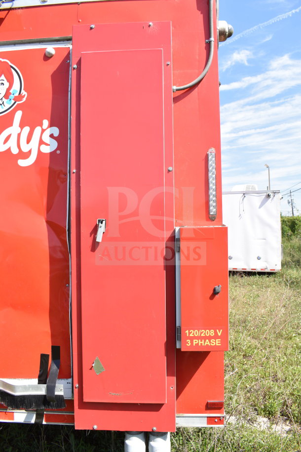 Red Wendy's food trailer by Titanium Cargo Trailers, showing exterior panel with 120/208 V 3 Phase marking.