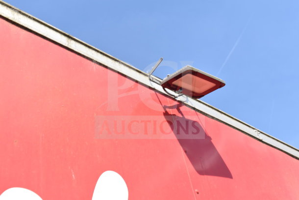 Red exterior of a 2021 Titanium Cargo Trailer with mounted security light. Part of Wendy's Food Trailer setup.