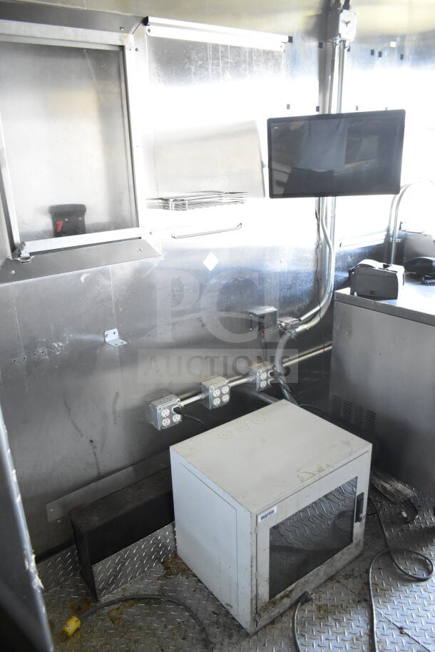 Interior of 2021 Diamond Cargo 8.5'x24' food trailer. Features include CaptiveAire grease hood, electrical outlets, and Turbochef ovens.