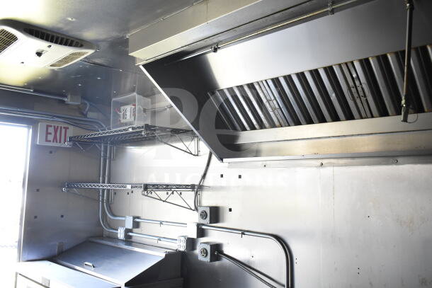 2021 Diamond Cargo 8.5'x24' food trailer interior showing CaptiveAire grease hood and metal shelving.