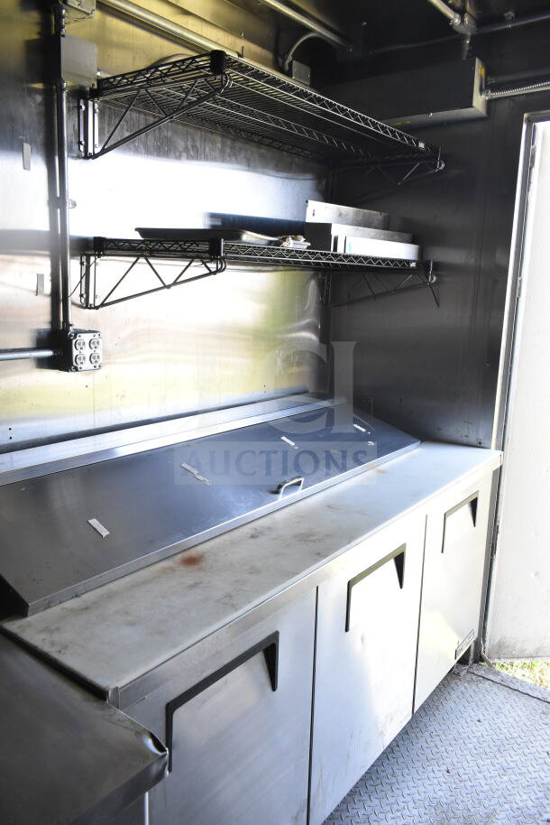 2021 Diamond Cargo 8.5'x24' food trailer interior with stainless steel workspace, storage units, wire shelves, and grease hood.