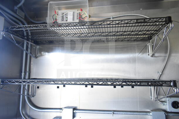 Wire shelving inside 2021 Diamond Cargo 8.5'x24' food trailer, featuring electrical components and metal wall mounts, in excellent condition.