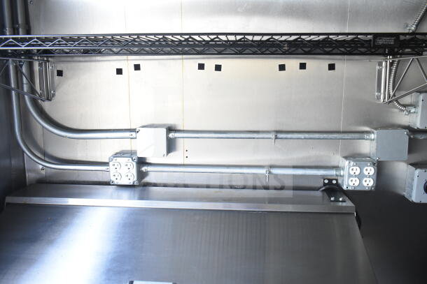 Interior of 2021 Diamond Cargo 8.5'x24' food trailer showing electrical outlets and piping along stainless steel wall.