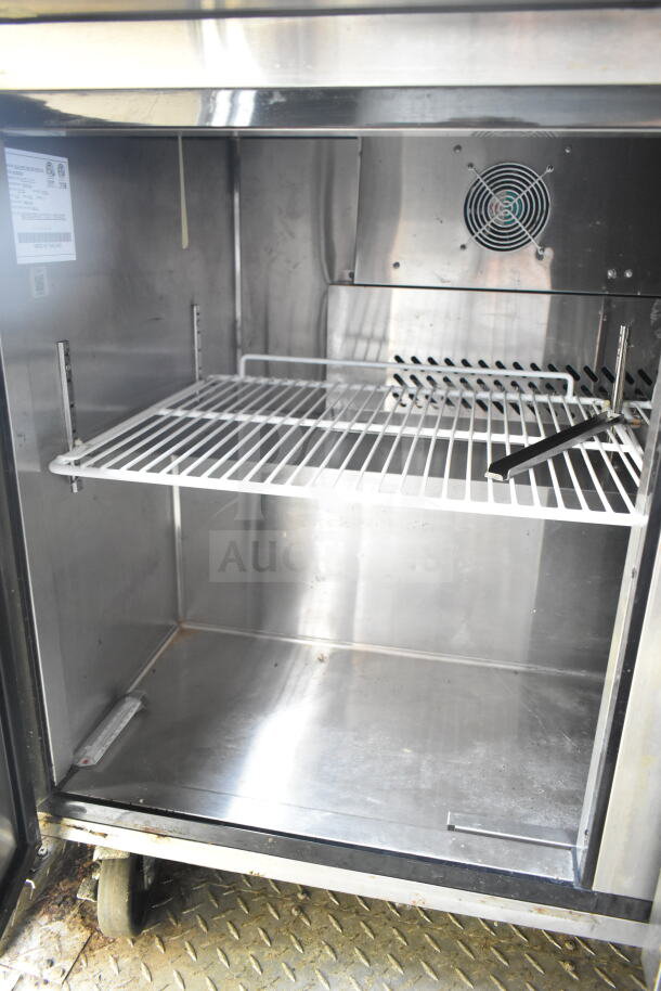 Interior of a 2021 Diamond Cargo food trailer showing stainless steel refrigeration unit with ventilation fan and wire shelf.