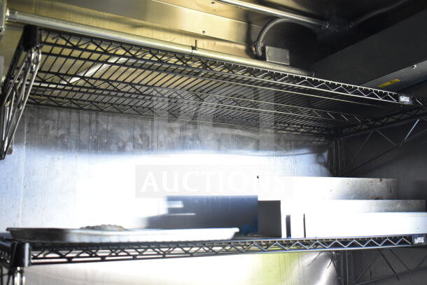 Interior of 2021 Diamond Cargo 8.5'x24' food trailer with wire shelving, showing clean metal surfaces and storage space.