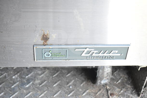 True Refrigerator label on Diamond Cargo food trailer, featuring natural refrigerant. Visible wear on surface.