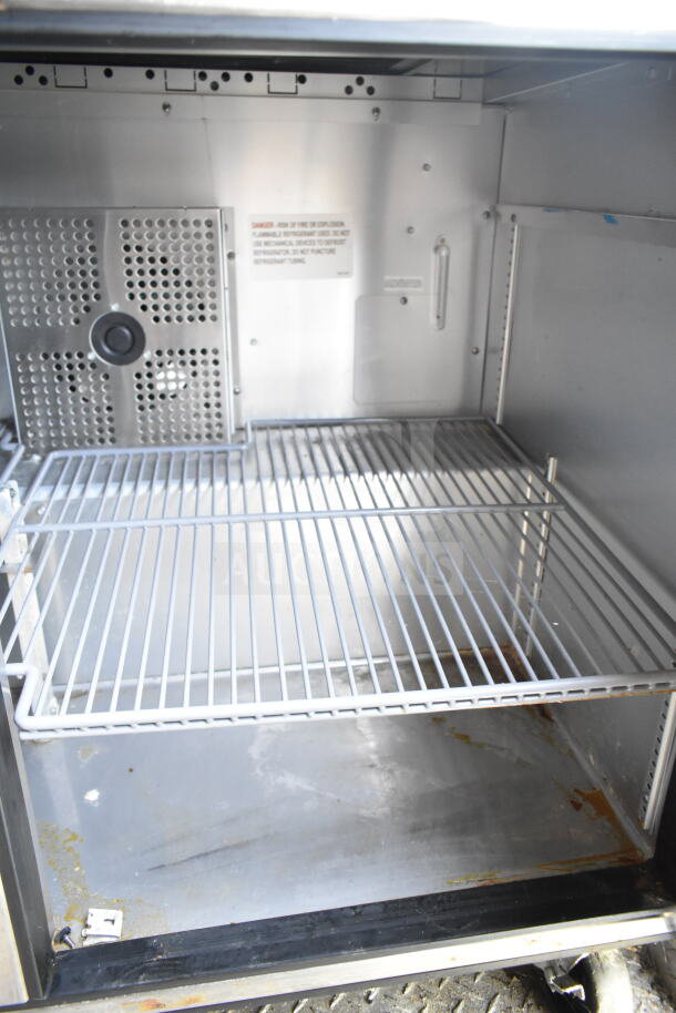 Interior of a 2021 Diamond Cargo 8.5'x24' food trailer showing refrigeration unit. Features shelving and visible grease mark.
