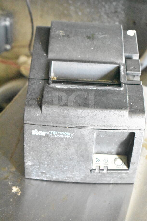 Star TSP100III thermal receipt printer, black, showing wear, with Wi-Fi indicator, ready and status buttons visible.