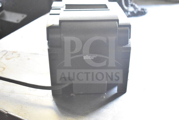 Black equipment casing with the label "Star" on a surface. Cable extending from the bottom. Clean condition.