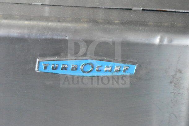 Close-up of Turbochef logo on the 2021 Diamond Cargo 8.5'x24' Food Trailer, featuring CaptiveAire grease hood and refrigeration.