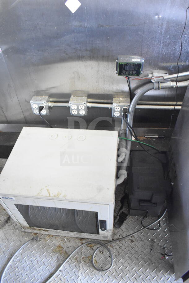 Interior power outlets and equipment inside a 2021 Diamond Cargo food trailer. Visible wiring and control panel.