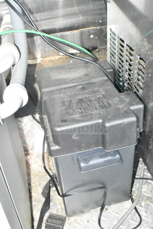 Battery compartment in 2021 Diamond Cargo 8.5'x24' food trailer, showing wiring and surrounding protective casing.