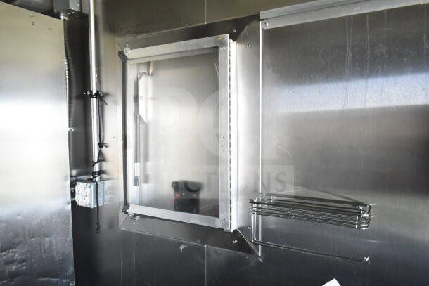 2021 Diamond Cargo 8.5'x24' food trailer interior, featuring stainless steel walls and shelving, electrical outlets visible.