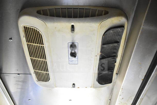 Ceiling fan in Diamond Cargo food trailer, slightly worn, featuring manual controls and ventilation grilles.